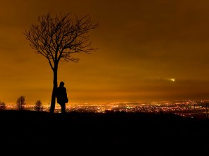 1449634-2-silhouette-of-man-stood-by-tree-overlooking-manchester-city-centre-at-night